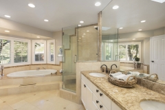Luxury bathroom interior in marble with glass shower and round double sink.