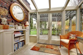 Garden room wall with clock and book shelves